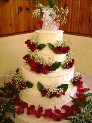 red and white tiered wedding cakes with roses and fountains